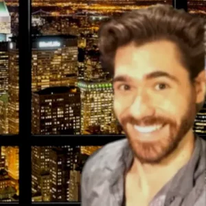 a man smiling in front of a window