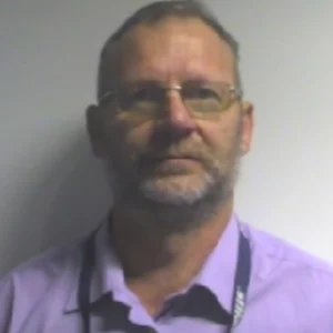 a man wearing glasses and a purple shirt